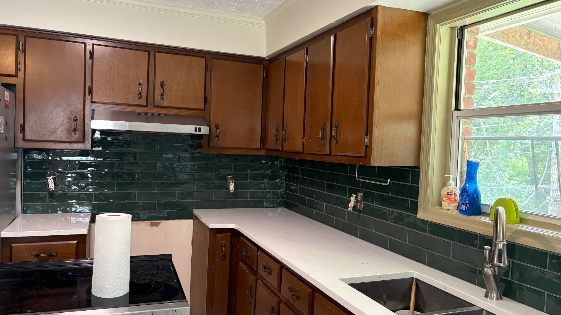 Kitchen backsplash detail with dark wood cabinets and green subway tile in Frankfort, KY