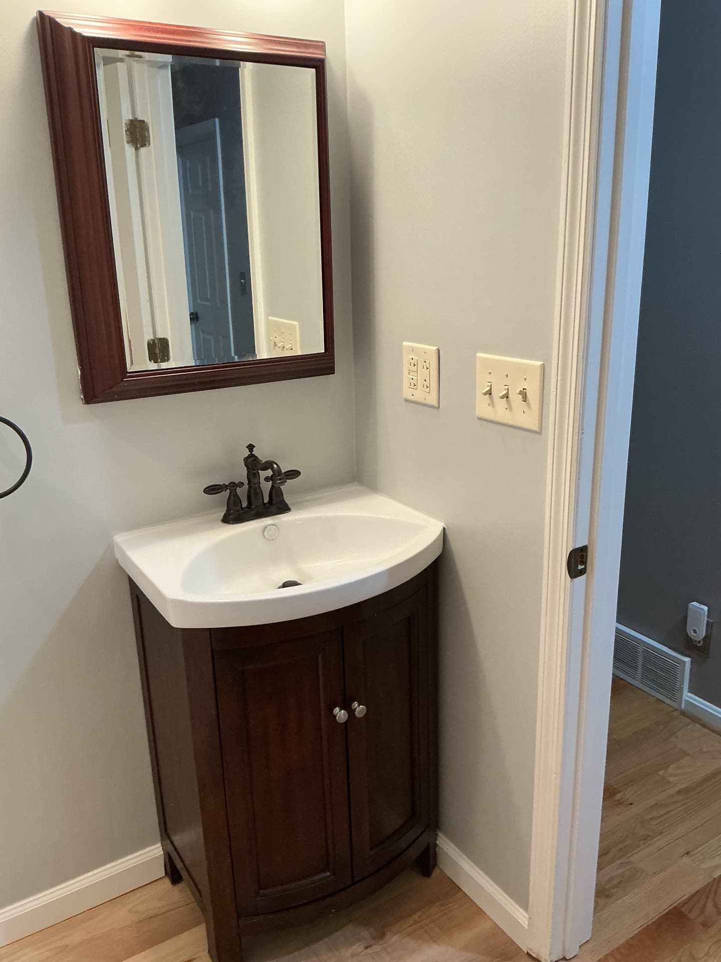 New dark wood vanity with white sink top and framed mirror in Georgetown, KY