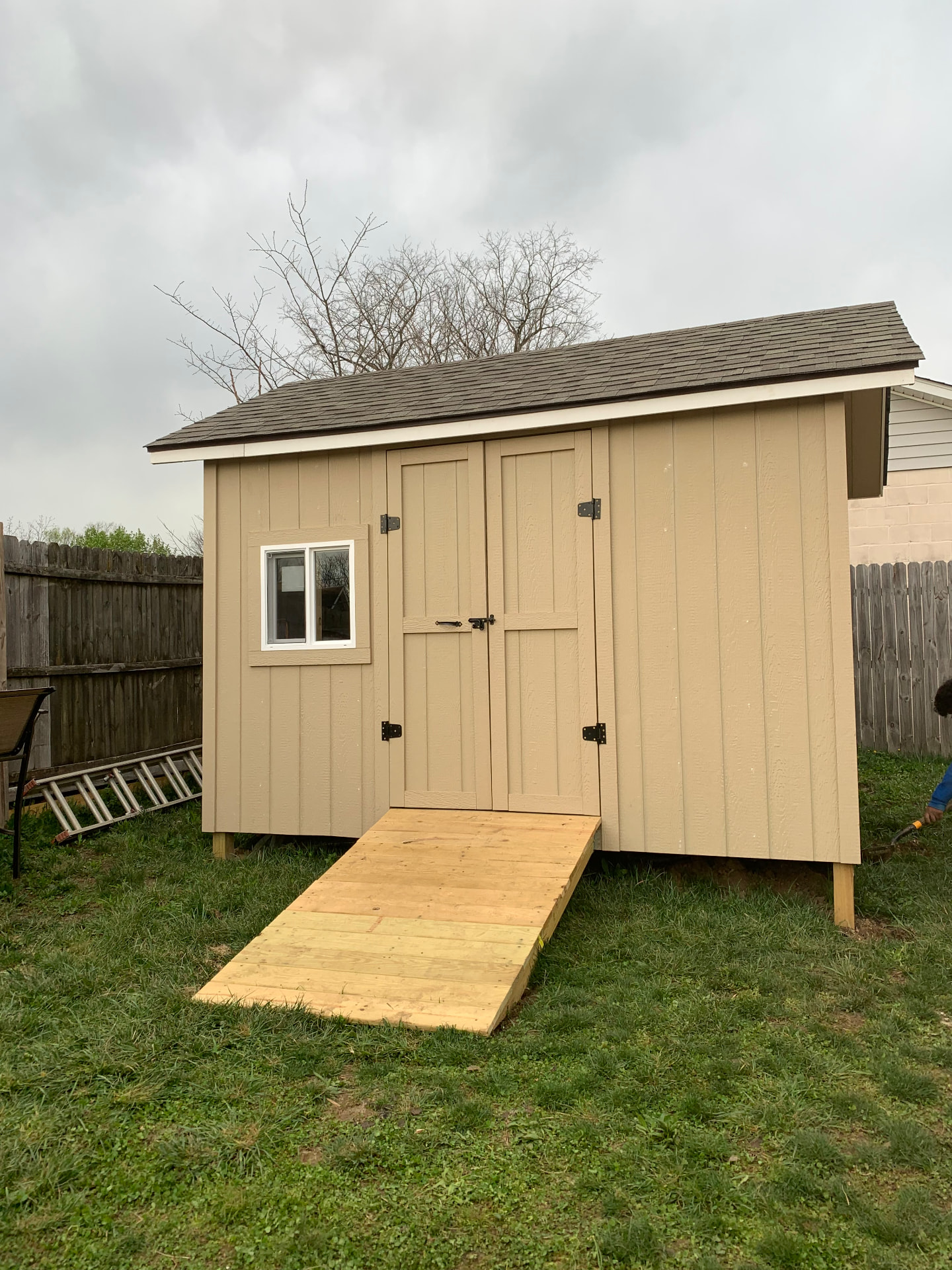 Custom-built tan storage shed with shingle roof and ramp in Georgetown, KY